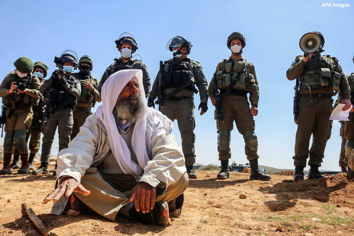A Palestinian protester argues with Israeli troops during a rally protesting the confiscation of land for the Israeli settlement of Karmel, near Yatta village south of Hebron city in the occupied West Bank, on March 19, 2021, before the Israeli army declared the area a closed military zone and ordered demonstrators to leave. Stated in numerous EU Foreign Affairs Council conclusions, settlements are illegal under international law, constitute an obstacle to peace and threaten to make a two-state solution impossible. The EU has reiterated its strong opposition to Israel's settlement policy and actions taken in this context, such as building the separation barrier beyond the 1967 line, demolitions and confiscation - including of EU funded projects - evictions, forced transfers including of Bedouins, illegal outposts and restrictions of movement and access. Photo by Mosab Shawer