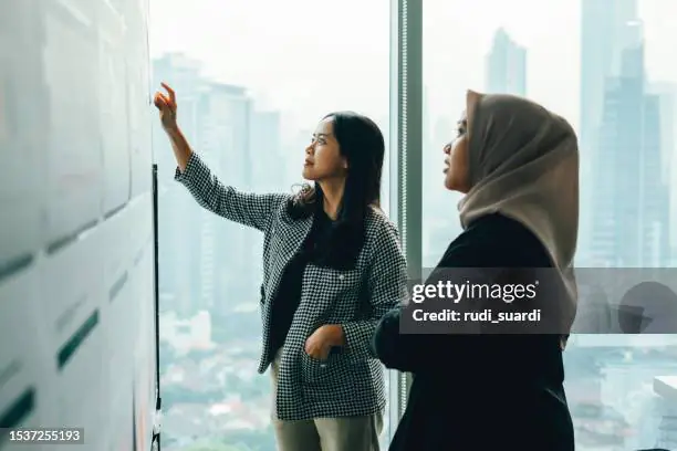 Asian people working and discussion on whiteboard in office
