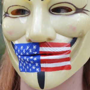 A masked protestor is seen at a rally calling for the release for Pfc. Bradley Manning outside of Ft McNair on July 26, 2013 in Washington, DC. The trial of Manning, accused of "aiding the enemy" by giving secret documents to WikiLeaks, is entering its final stage as both sides present closing arguments.  AFP PHOTO/Mandel NGAN        (Photo credit should read MANDEL NGAN/AFP/Getty Images)
